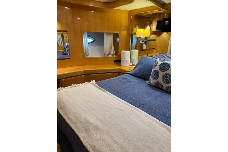 "fortunate" Yacht Photos Pics Luxurious bedroom interior of 1995 JOHNSON 65 Flybridge Motoryacht with elegant wood paneling.