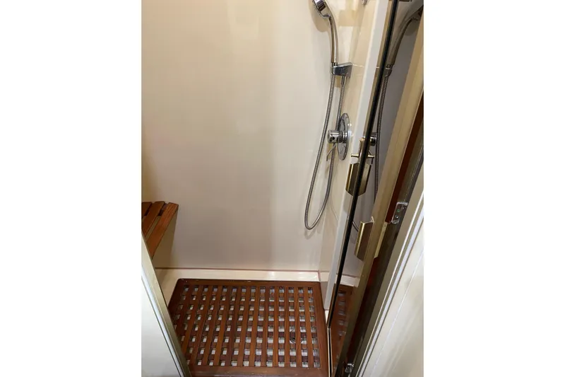 "fortunate" Yacht Photos Pics Shower area in 1995 JOHNSON 65 Flybridge Motoryacht with wooden floor and chrome fixtures.