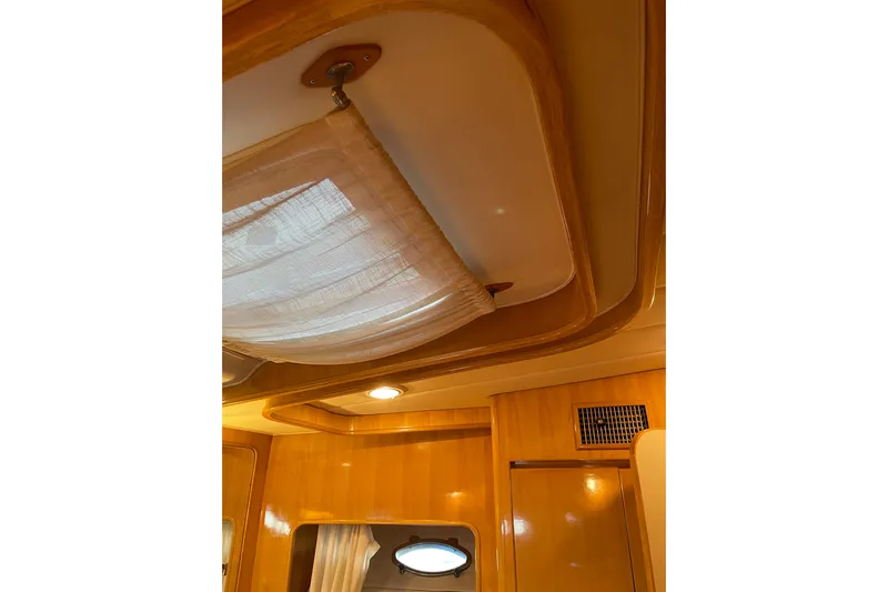"fortunate" Yacht Photos Pics Interior ceiling of 1995 JOHNSON 65 Flybridge Motoryacht with wooden finish and lighting.