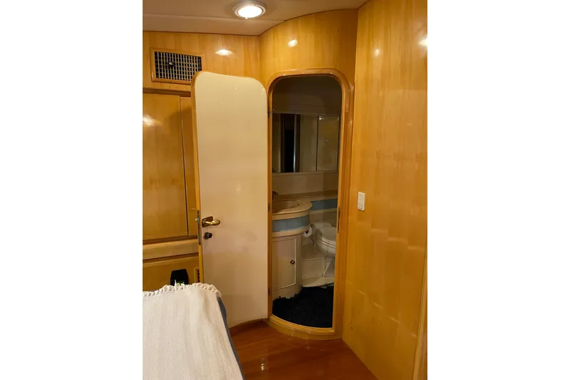 "fortunate" Yacht Photos Pics Interior of 1995 JOHNSON 65 Flybridge Motoryacht with wooden paneling and bathroom access.