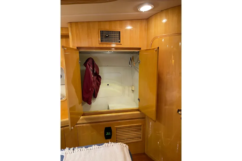 "fortunate" Yacht Photos Pics Interior of 1995 JOHNSON 65 Flybridge Motoryacht with open wooden cabinet.