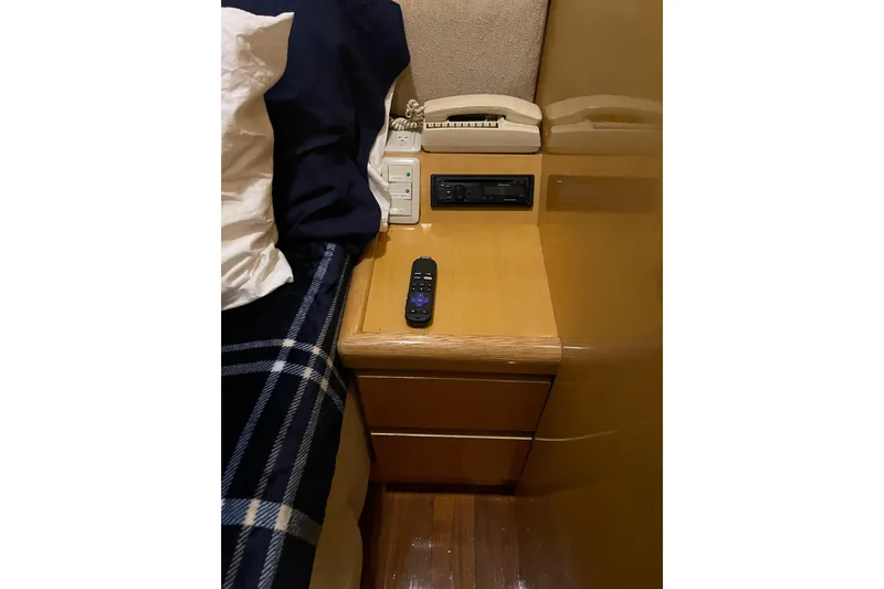 "fortunate" Yacht Photos Pics Bedside table with remote, phone, and controls on Johnson 65 Flybridge Motoryacht, 1995.