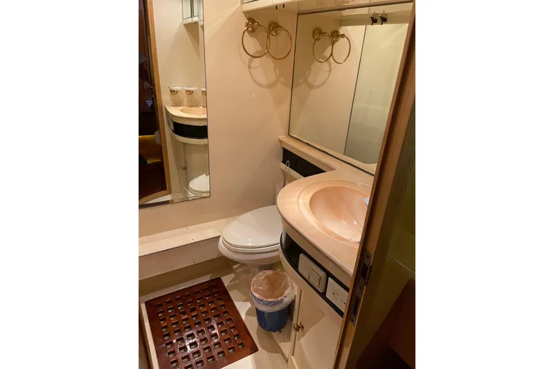 "fortunate" Yacht Photos Pics Bathroom interior of 1995 JOHNSON 65 Flybridge Motoryacht with sink, toilet, and mirror.