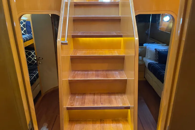 "fortunate" Yacht Photos Pics Interior of 1995 JOHNSON 65 Flybridge Motoryacht with wooden stairs and cozy cabins.