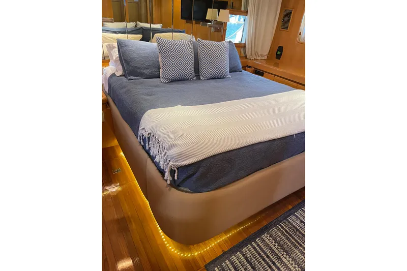 "fortunate" Yacht Photos Pics Luxurious bedroom interior of 1995 JOHNSON 65 Flybridge Motoryacht with elegant bedding and ambient lighting.