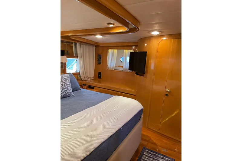 "fortunate" Yacht Photos Pics Luxurious cabin interior of 1995 JOHNSON 65 Flybridge Motoryacht with wood paneling and modern amenities.