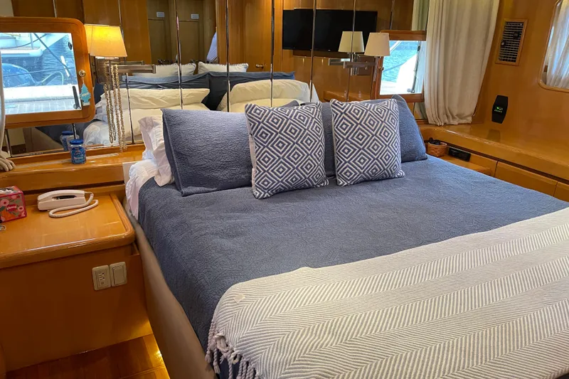 "fortunate" Yacht Photos Pics Luxurious bedroom interior of 1995 JOHNSON 65 Flybridge Motoryacht with elegant bedding and decor.