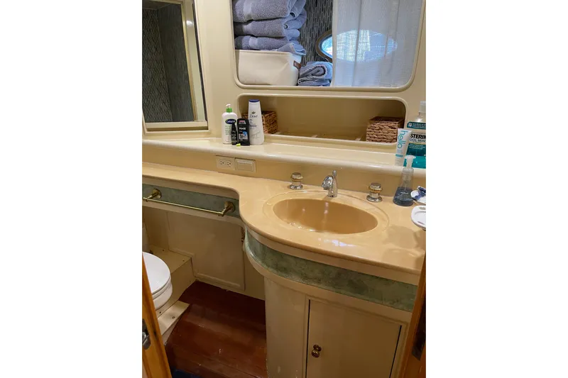 "fortunate" Yacht Photos Pics Bathroom interior of 1995 JOHNSON 65 Flybridge Motoryacht with sink and toiletries.