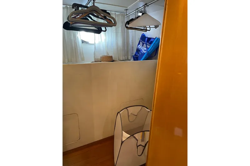 "fortunate" Yacht Photos Pics Laundry area with hangers and basket on Johnson 65 Flybridge Motoryacht, 1995 model.