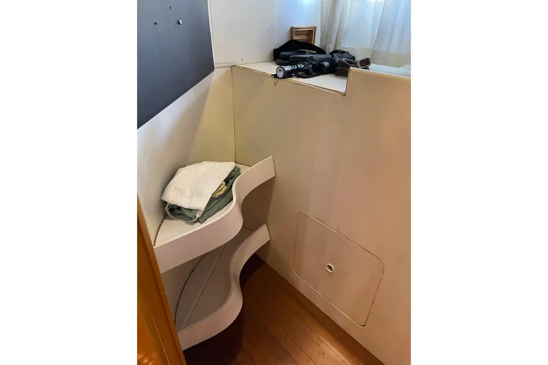 "fortunate" Yacht Photos Pics Interior corner of 1995 JOHNSON 65 Flybridge Motoryacht with shelves and folded linens.