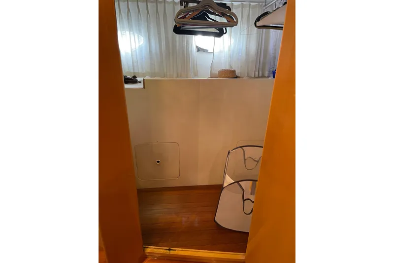 "fortunate" Yacht Photos Pics Interior view of 1995 JOHNSON 65 Flybridge Motoryacht with wooden flooring and hangers.