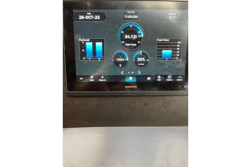 "fortunate" Yacht Photos Pics Garmin display on 1995 JOHNSON 65 Flybridge Motoryacht showing fuel, water levels, and temperature.