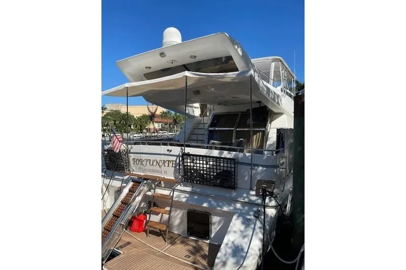 "fortunate" Yacht Photos Pics 1995 Johnson Flybridge Motoryacht docked, featuring spacious deck and canopy, sunny day.