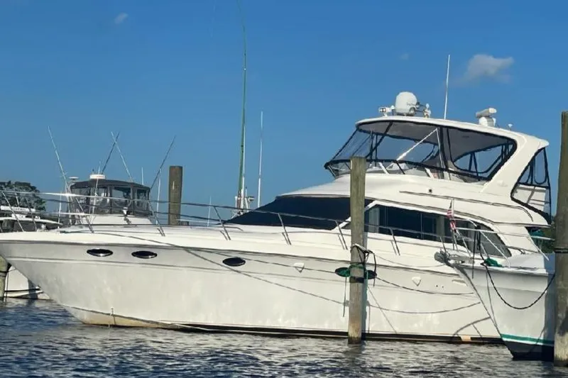  Yacht Photos Pics 2004 Sea Ray 480 Sedan Bridge yacht docked at marina under clear blue sky.