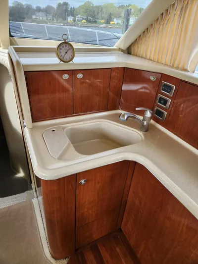  Yacht Photos Pics 2004 Sea Ray 480 Sedan Bridge kitchen with wood cabinetry and sink.