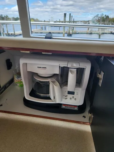  Yacht Photos Pics Coffee maker in a 2004 Sea Ray 480 Sedan Bridge yacht kitchen, with marina view.
