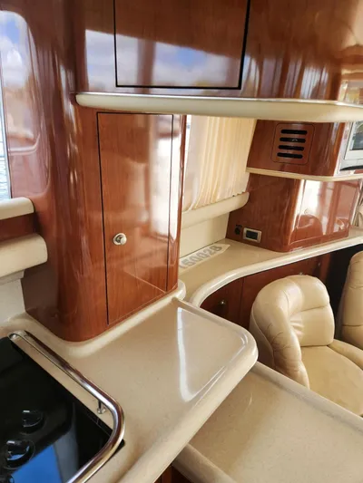  Yacht Photos Pics 2004 Sea Ray 480 Sedan Bridge interior with polished wood and beige leather seating.