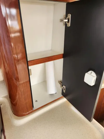  Yacht Photos Pics Open cabinet on 2004 Sea Ray 480 Sedan Bridge yacht, featuring wood finish and interior shelving.