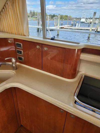  Yacht Photos Pics 2004 Sea Ray 480 Sedan Bridge kitchen with wood cabinets and water view.