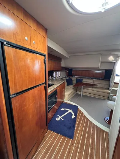 Little Wing Yacht Photos Pics 2008 Cruisers 420 Express yacht interior with kitchen, seating area, and wooden flooring.