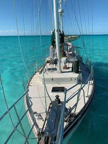 Drakus Yacht Photos Pics 1973 Skookum Ketch sailboat on clear turquoise water, viewed from the deck.