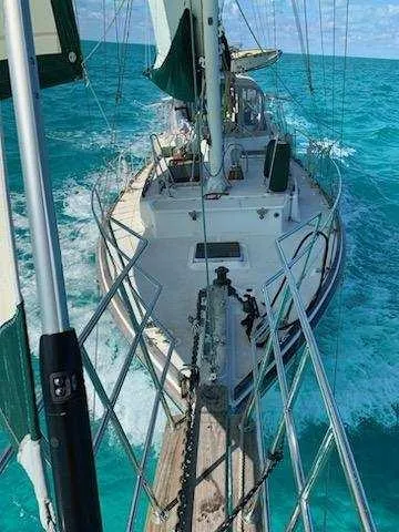 Drakus Yacht Photos Pics 1973 Skookum Ketch sailing on turquoise ocean waters, viewed from the bow.