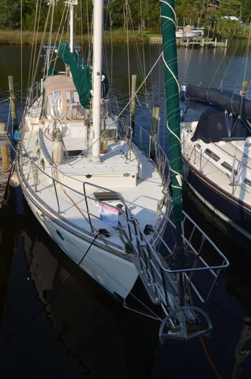 Drakus Yacht Photos Pics 1973 Skookum Ketch sailboat docked in a marina, featuring green sails and a white deck.