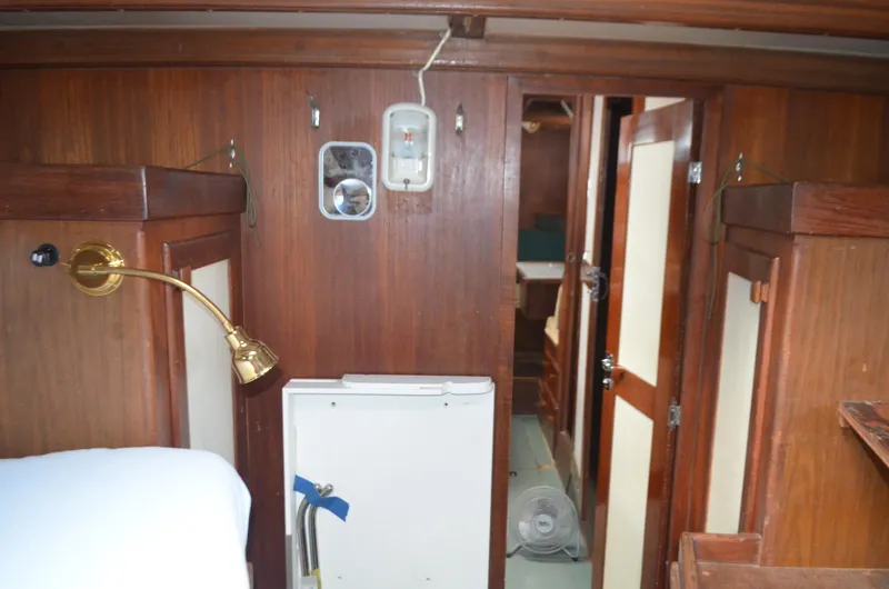 Drakus Yacht Photos Pics Interior of 1973 Skookum Ketch sailboat with wooden paneling and brass lamp.