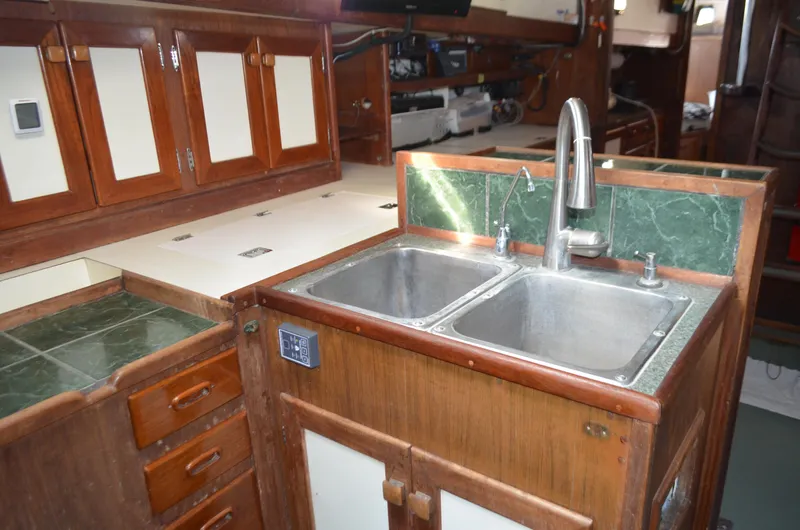 Drakus Yacht Photos Pics 1973 Skookum Ketch kitchen with dual sinks, wooden cabinets, and green countertops.