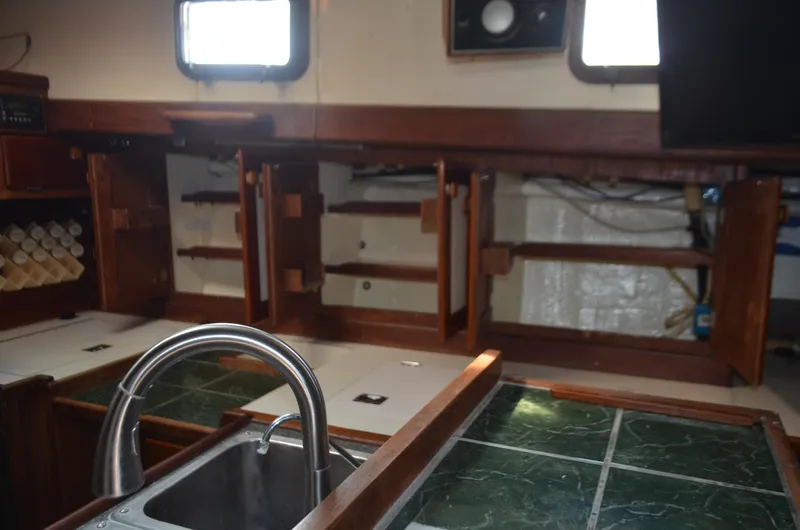 Drakus Yacht Photos Pics 1973 Skookum Ketch interior kitchen with wooden cabinets and stainless steel sink.