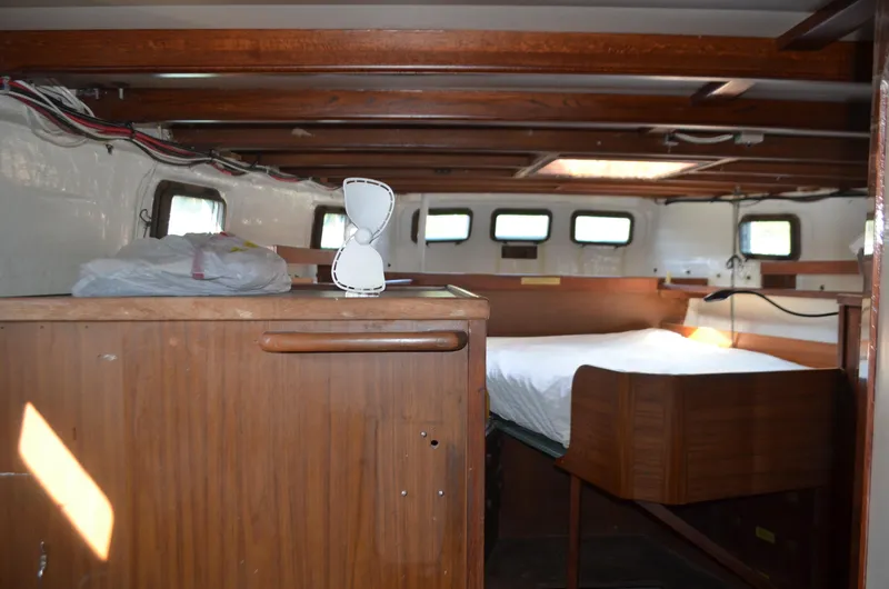 Drakus Yacht Photos Pics Interior of a 1973 Skookum Ketch sailboat with wooden furnishings and a cozy sleeping area.