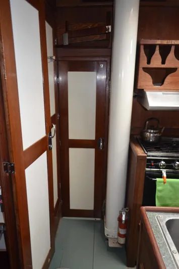 Drakus Yacht Photos Pics 1973 Skookum Ketch interior kitchen with wooden cabinets and stove.