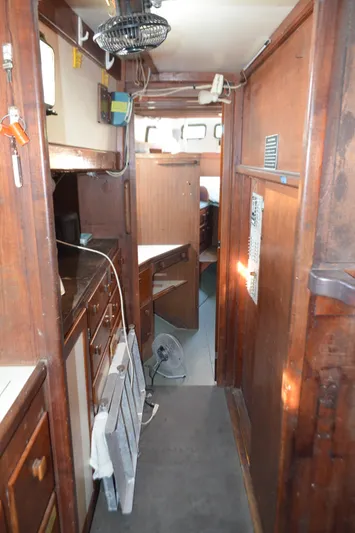 Drakus Yacht Photos Pics Interior of a 1973 Skookum Ketch sailboat with wooden cabinetry and compact layout.