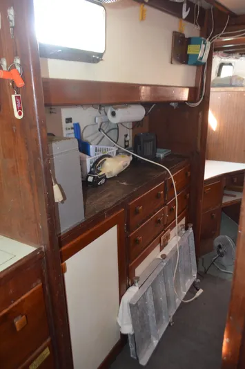 Drakus Yacht Photos Pics Interior of a 1973 Skookum Ketch sailboat with wooden cabinetry and nautical equipment.
