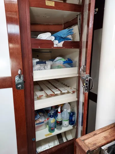 Drakus Yacht Photos Pics Wooden cabinet with shelves storing cleaning supplies and towels on a 1973 Skookum Ketch.