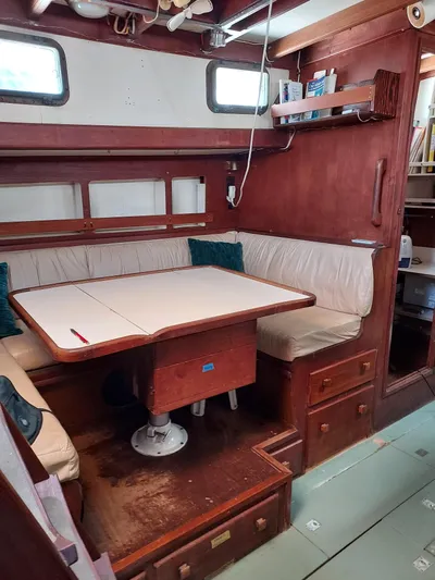 Drakus Yacht Photos Pics 1973 Skookum Ketch interior with wooden dining area and cushioned seating.