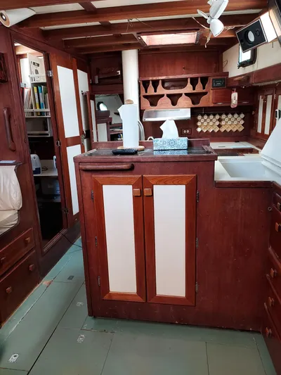 Drakus Yacht Photos Pics Interior of a 1973 Skookum Ketch sailboat with wooden cabinetry and nautical decor.