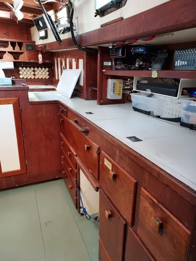 Drakus Yacht Photos Pics Interior of a 1973 Skookum Ketch sailboat with wooden cabinetry and organized storage.