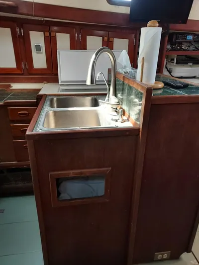Drakus Yacht Photos Pics 1973 Skookum Ketch kitchen with wooden cabinetry and stainless steel sink.