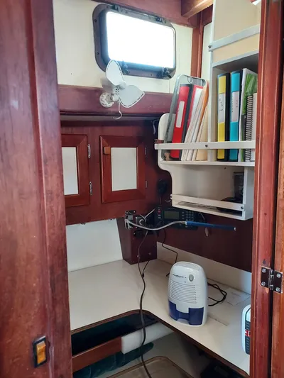 Drakus Yacht Photos Pics Interior of a 1973 Skookum Ketch sailboat with wooden cabinetry and organized workspace.