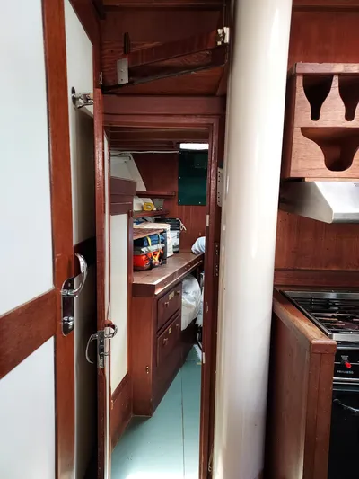 Drakus Yacht Photos Pics Interior of a 1973 Skookum Ketch sailboat, featuring wooden cabinetry and compact kitchen space.