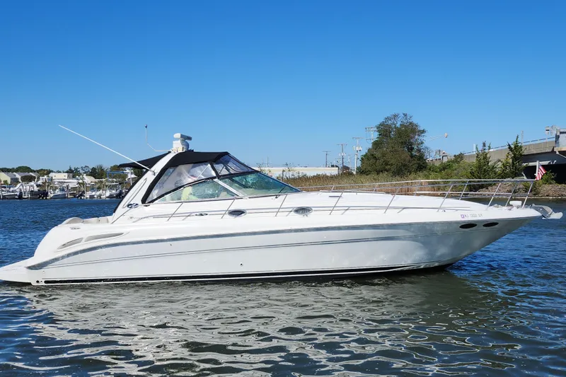  Yacht Photos Pics 2002 Sea Ray 410 Sundancer yacht on calm water under clear blue sky.