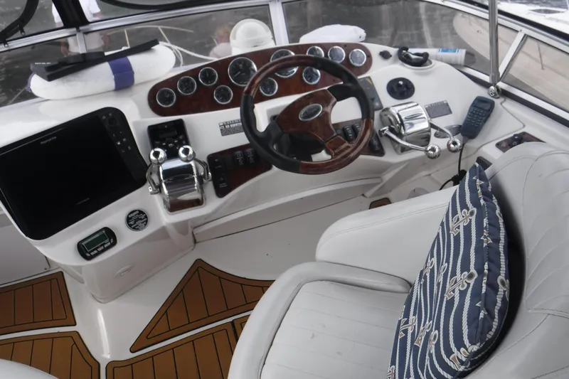  Yacht Photos Pics 2007 Meridian 341 Sedan helm with wood accents, gauges, and nautical-themed cushion.