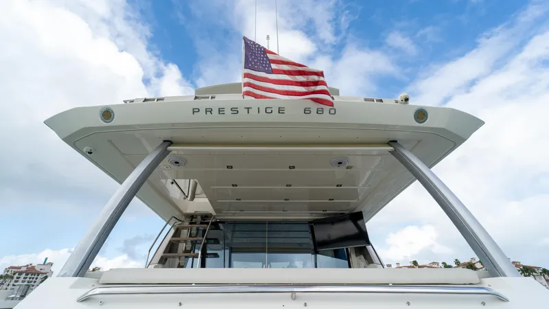 Yachtooma Yacht Photos Pics Luxury yacht Prestige 680, 2017 model, with American flag against blue sky.