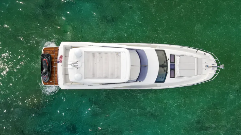 Yachtooma Yacht Photos Pics Aerial view of 2017 Present Yachts 680 on clear green water.