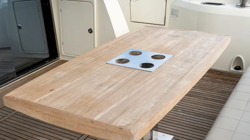 Yachtooma Yacht Photos Pics Wooden table on 2017 Present Yachts 680 deck, featuring built-in cup holders.