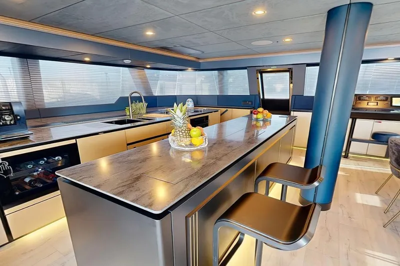Catallaxy Yacht Photos Pics Luxurious interior of 2024 Sunreef 60 Sail Eco yacht with modern kitchen and seating.