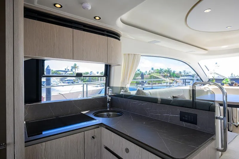 Bg 53 Yacht Photos Pics Luxurious interior of 2024 Azimut 53 Fly yacht with modern kitchen and scenic window view.