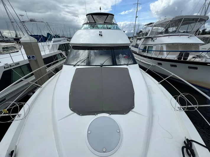 Endymion Yacht Photos Pics 2006 Carver 56 Voyager yacht docked at marina under cloudy sky.