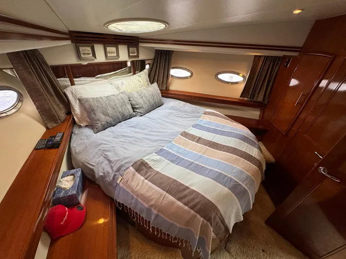 Endymion Yacht Photos Pics Luxurious bedroom interior of 2006 Carver 56 Voyager yacht with cozy bedding and elegant wood finish.